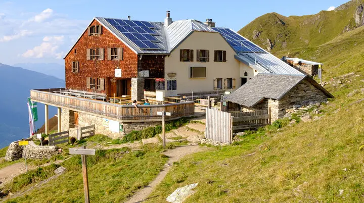 Ein Bild der Karl-von-Edel-Hütte mit idyllischer Landschaft im Hintergrund  | © DAV Wuerzburg 