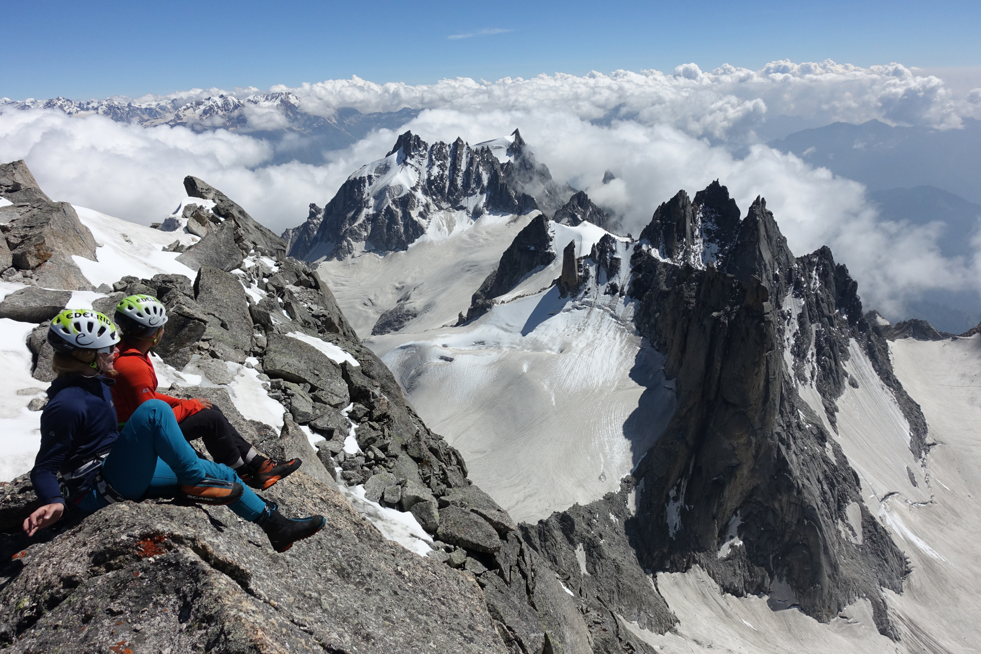 Zwei Bergsteiger sitzen auf dem Gipfel und genießen eine großartige Bergkulisse | © DAV/Expedkader